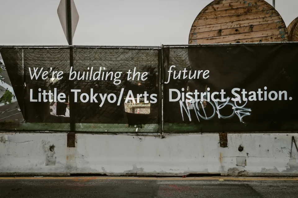 Black banner with white text "We're building the future - Little Tokyo/Arts District Station" in Los Angeles, California.